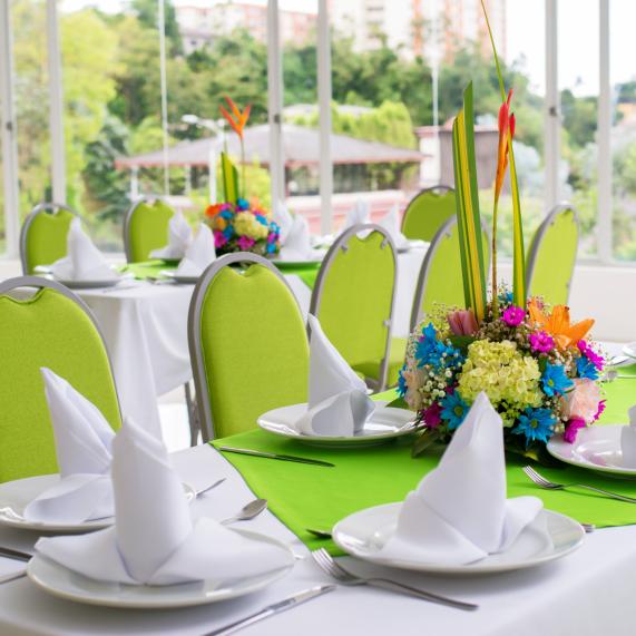 Salón con mesas y sillas verdes